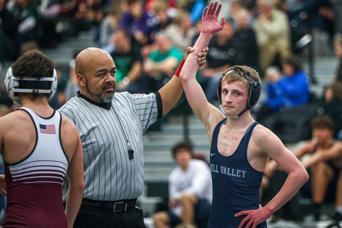 With his hand at his side, junior Jeredy Nilges gets his hand raised after winning his match. 