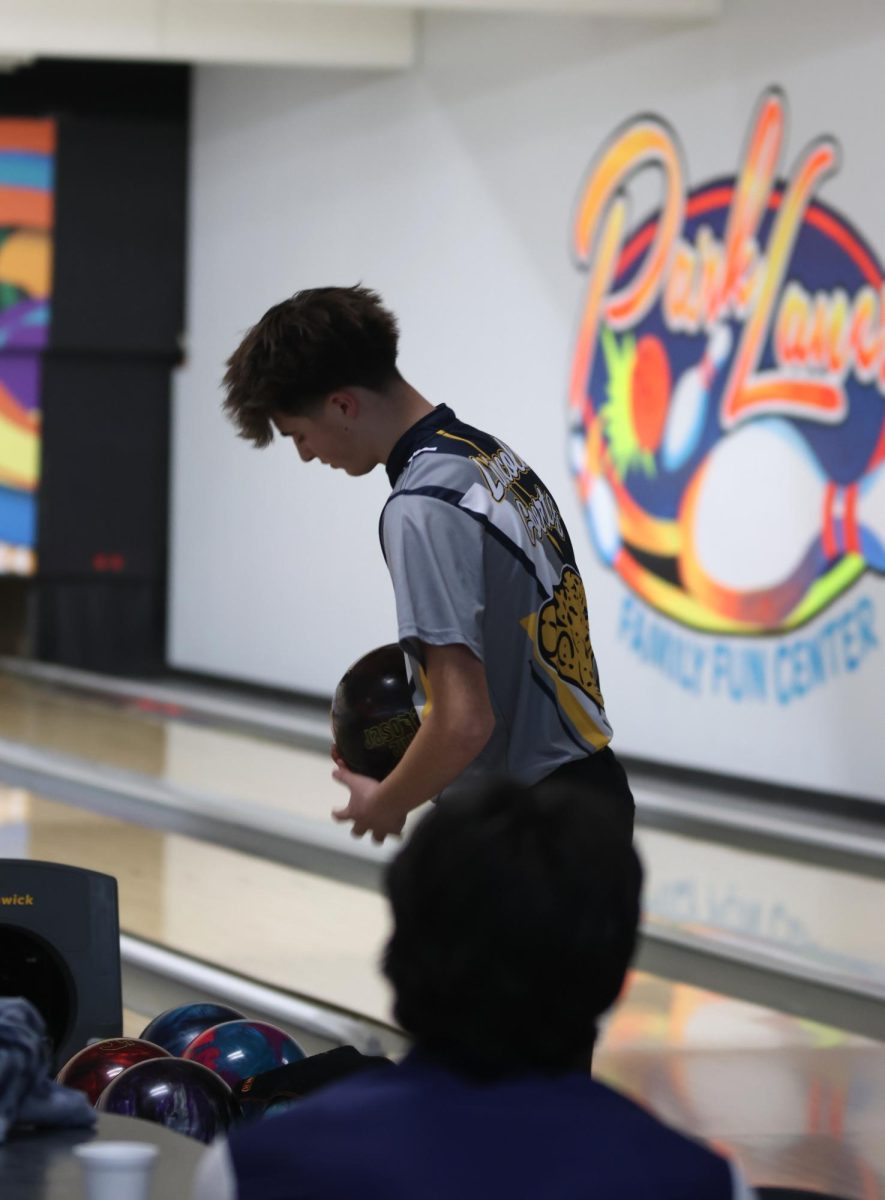 Getting ready to bowl, sophomore Lincoln Goertz grabs a ball from the stand. 