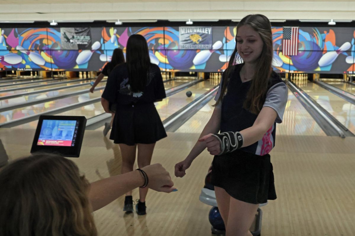 Smiling after bowling a strike, junior Layla Gonzalez gives junior Abby Haney a fistbump.