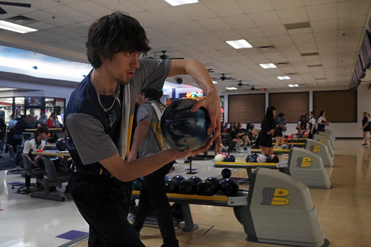 Junior Jake Brown looks at the pins while approaching the lane.