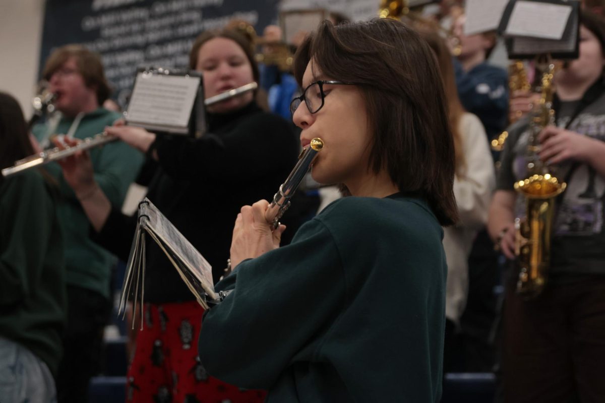 Playing the flute, freshman Calder Hsu looks at his music to get the notes right.
