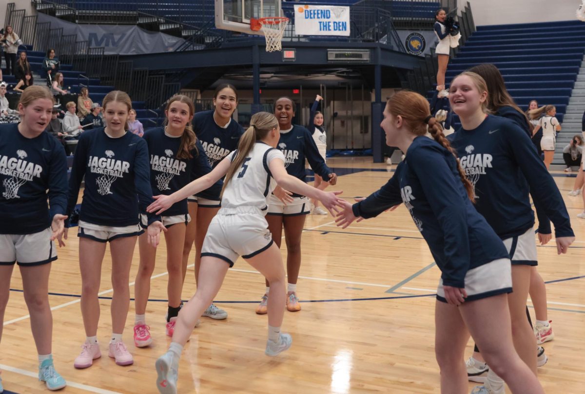 Running through the team, senior Josie Benson receives high-fives from the underclass men.
