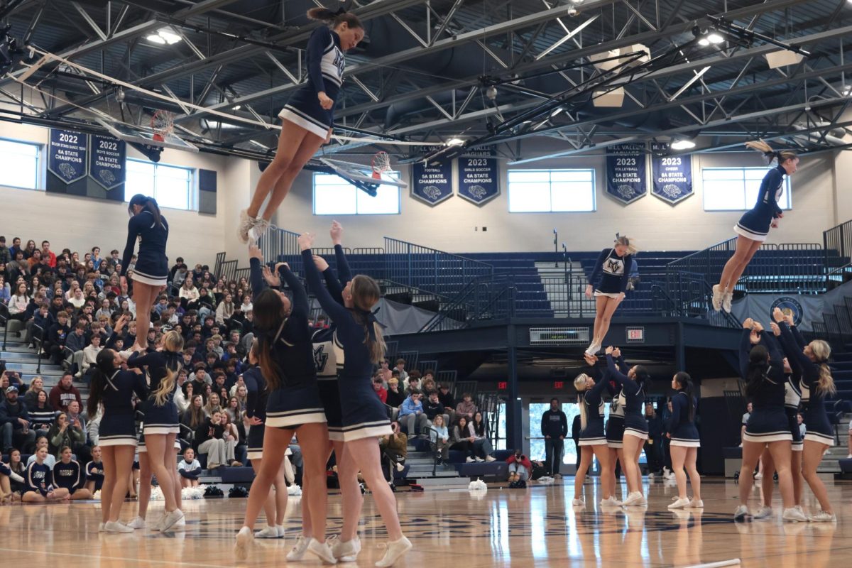 Doing stunts, the Mill Valley cheer flyers are thrown in the air.