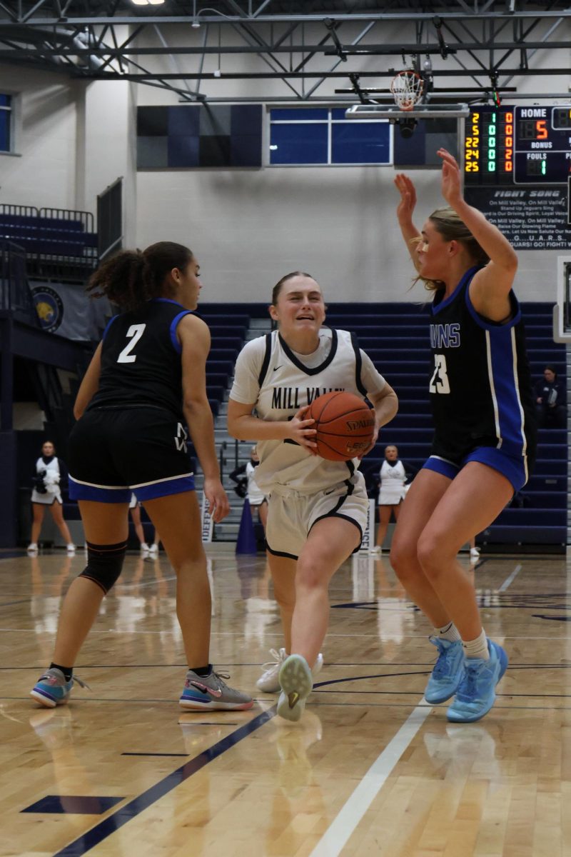 With a defender on her, sophomore Riley Marshall drives the ball to the basket.