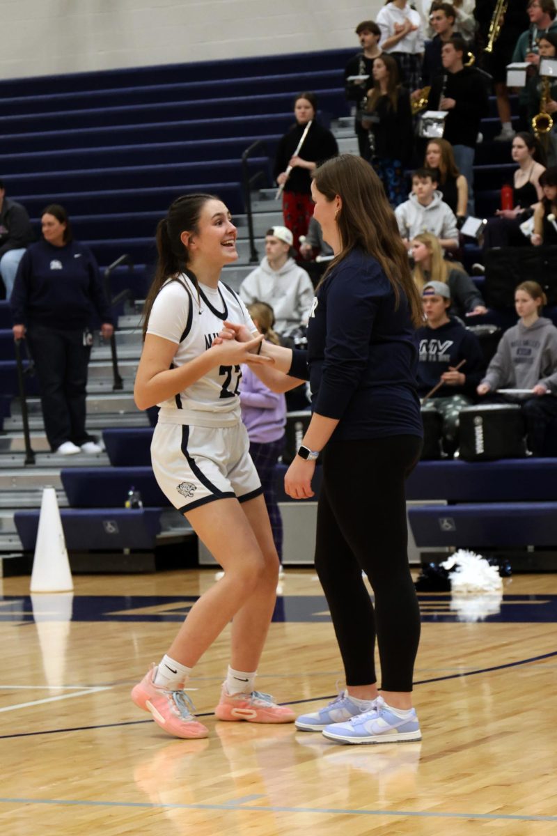 With a smile on her face, junior Paige Roth does her pregame handshake with senior Morgan Speciale.