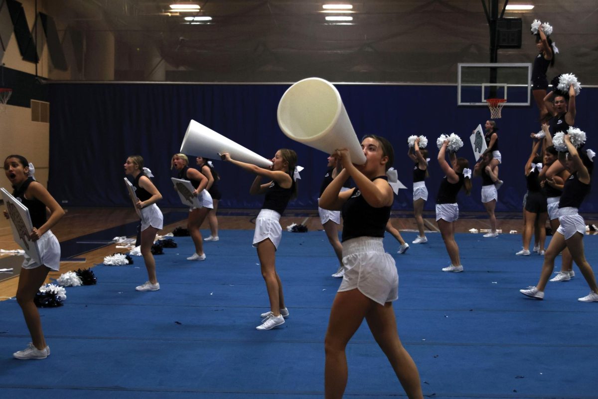 Freshman Brooklyn Roush yells into her megaphone during the fight song on Jan. 13