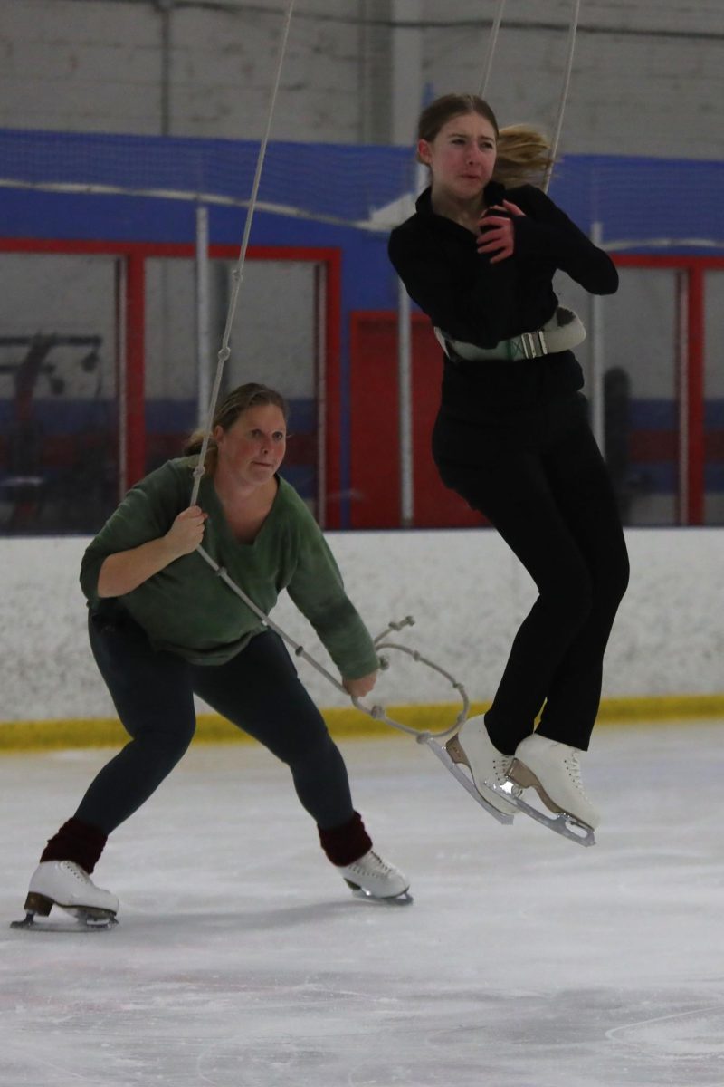 Freshman Delaney Konen spins in the air as her coach uses a jump harness to help turn her in the air during her lesson on Wednesday Feb. 5. 