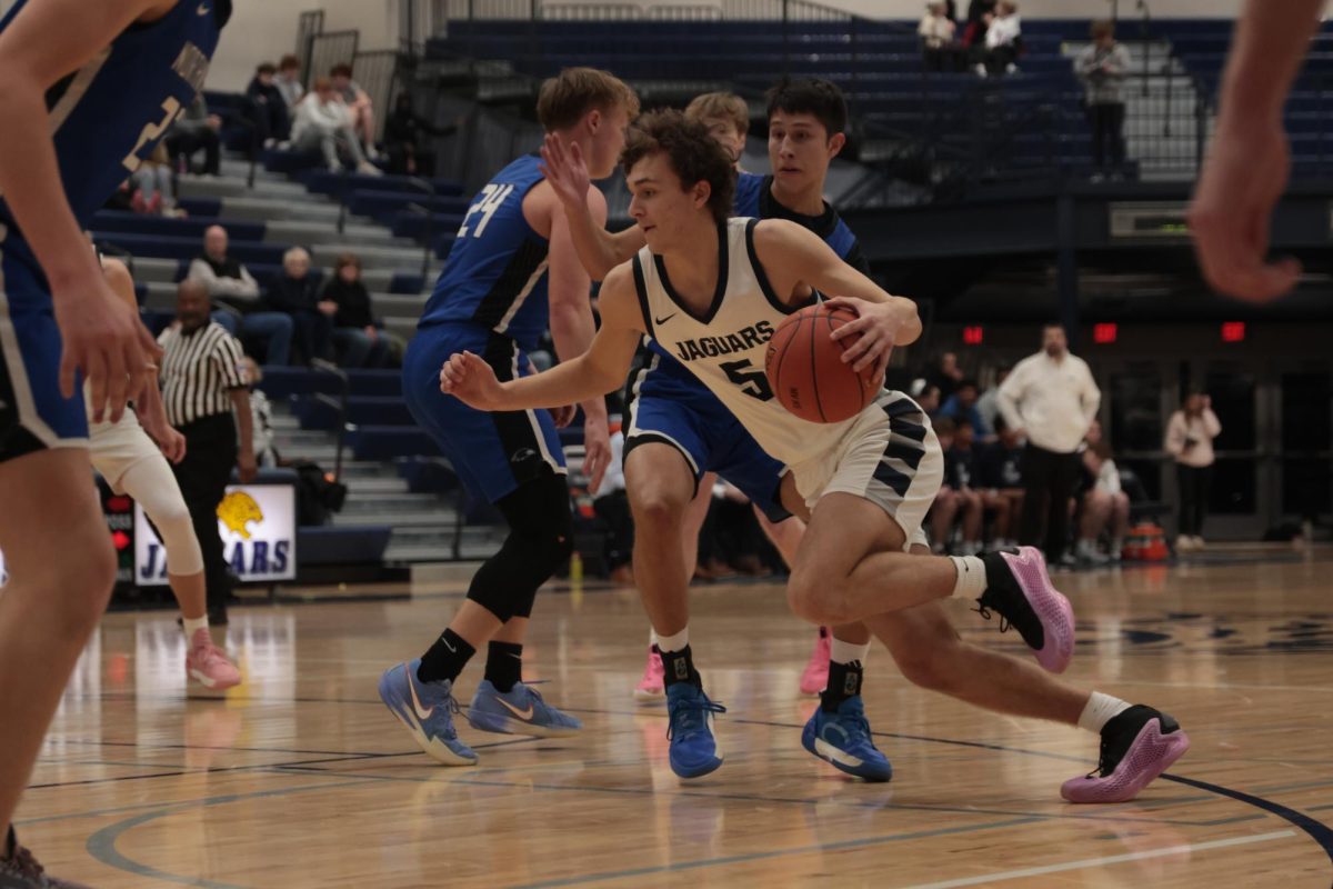 Dribbling towards the goal, junior Reece Riedel pushes through Olathe Northwest’s defense.