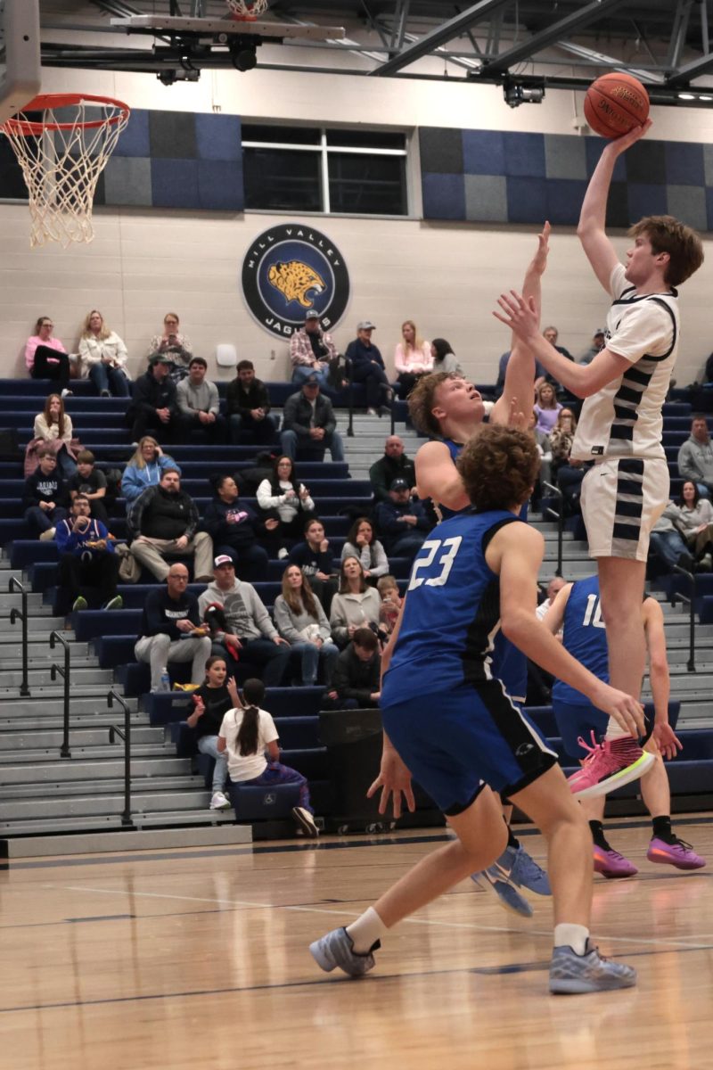 As the defence reaches to stop the shot, senior Carter Kaifes jumps in the air in hopes of scoring.