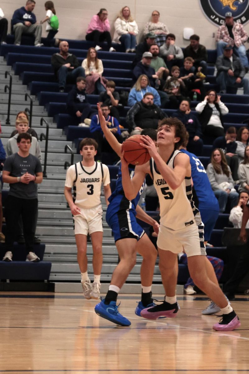 Junior Reece Riedel dribbles past his defender, attempting to reach the basket before the shot clock runs out.