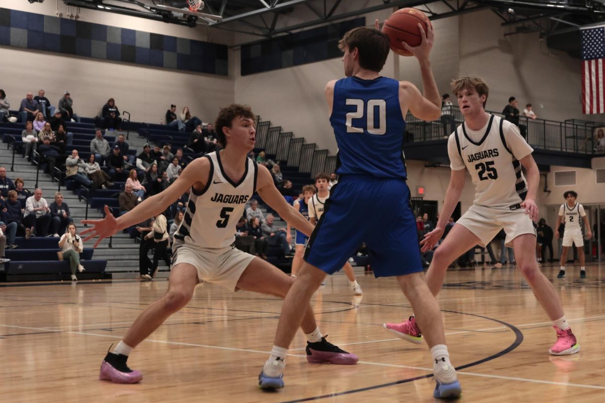 Attempting to distract Olathe Northwest and regain possession, junior Reece Riedel and senior Carter Kaifes team up to stop their opposition