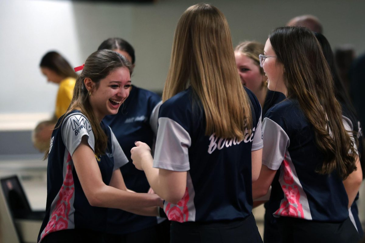 The team congratulates junior Layla Gonzalez after she makes a strike for the team. 