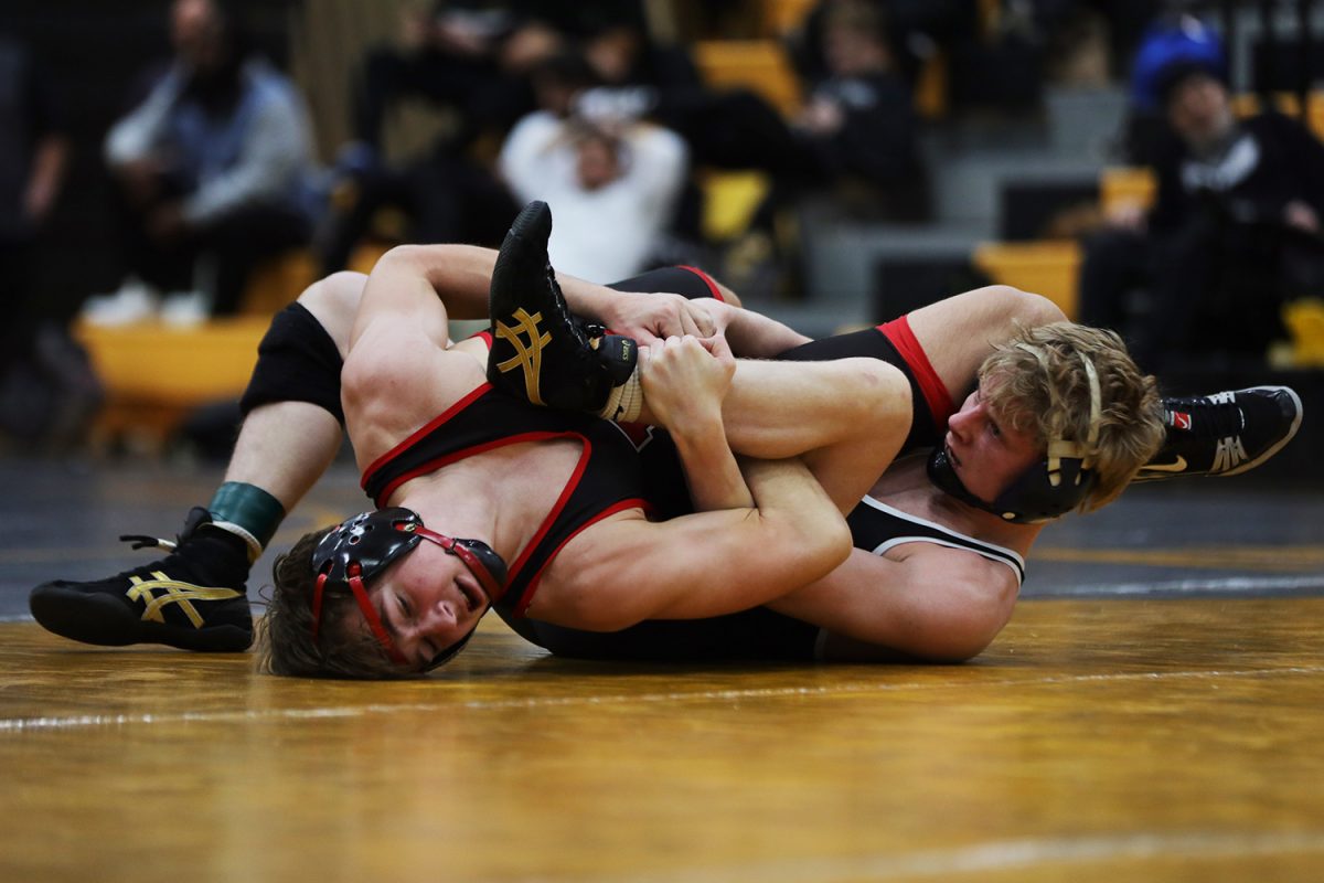 Arms tangled, senior Colton Bendure looks to get the pin.