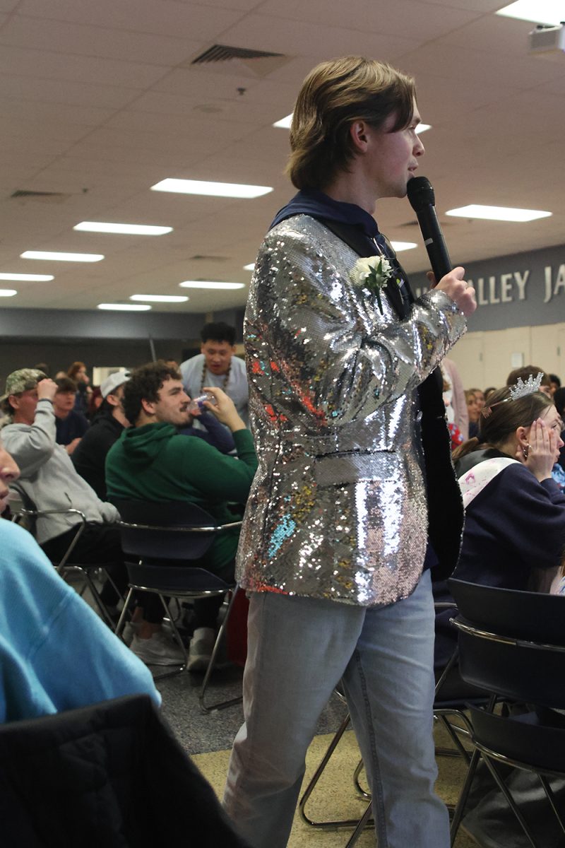 Mic in hand, teacher Carter Sebasto announces the question to the teams. 