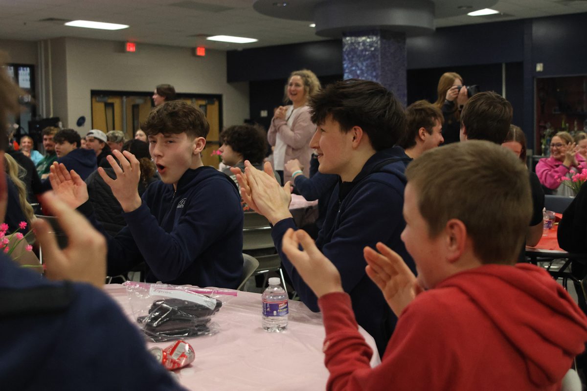 Celebrating, juniors Carter Clark and Jack Carpenter clap as they get a point.