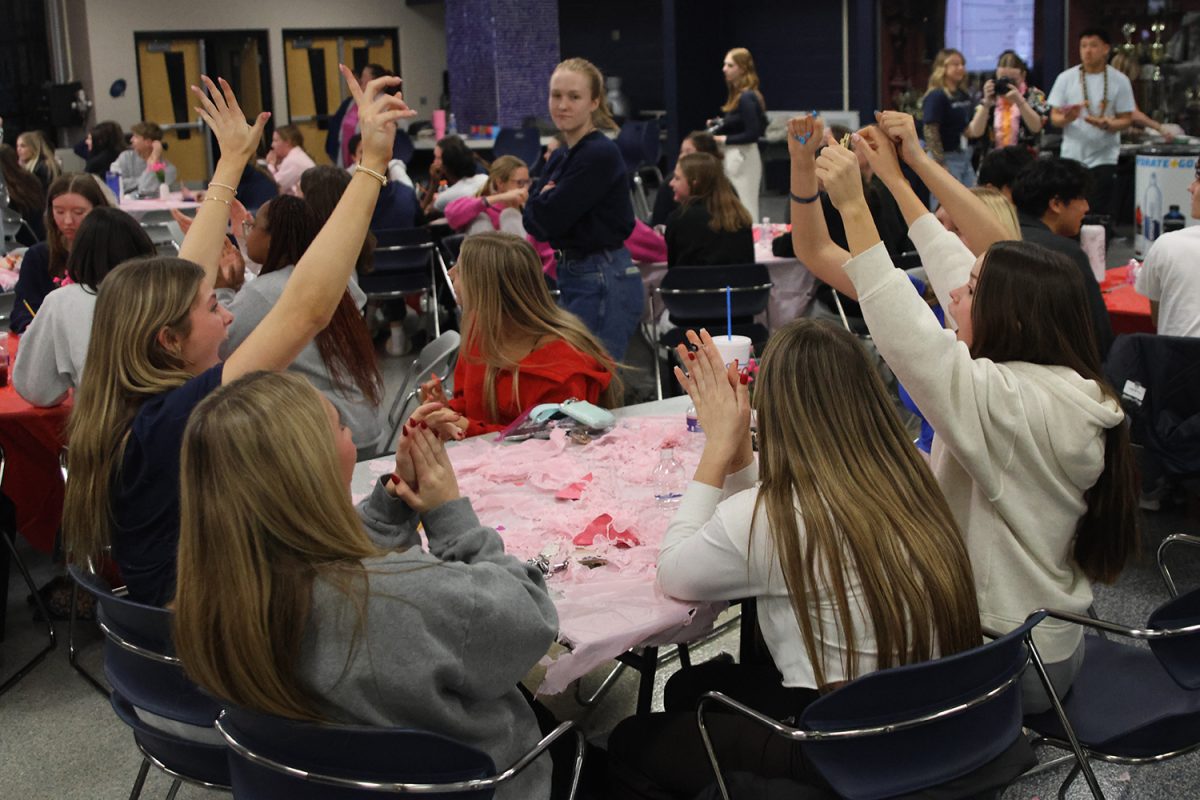 Hands in the air, the team celebrates after answering a question correctly.