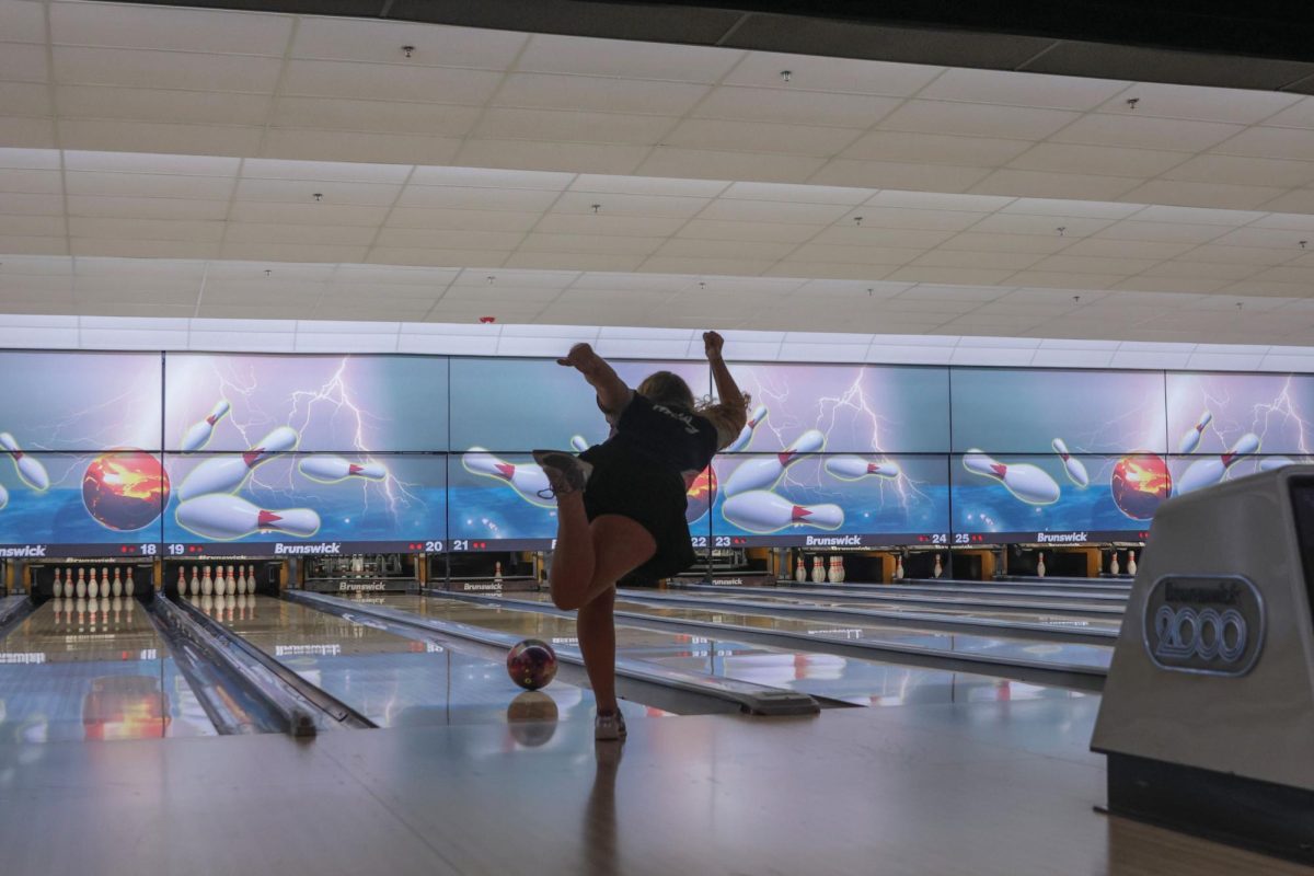 With her foot in the air, junior Abby Haney watches closely as the ball heads towards the pins. 