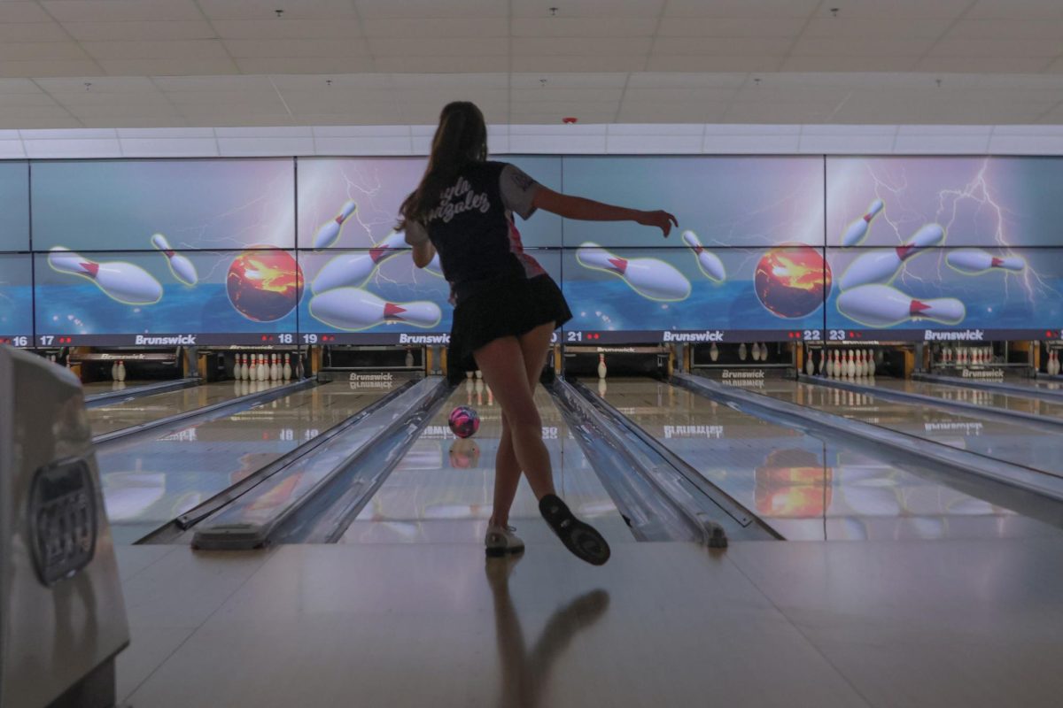 After rolling her bowling ball, junior Layla Gonzalez watches it go down the lane. 