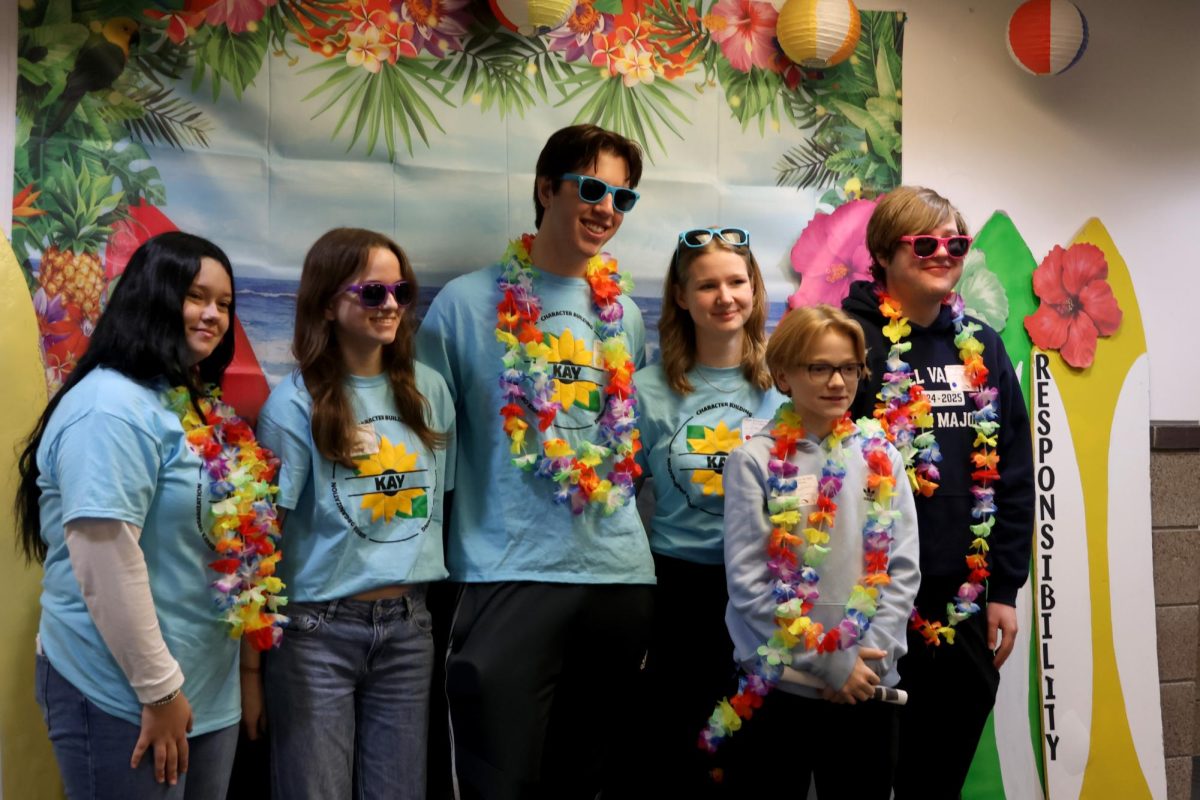 K.A.Y. club members line up in front of an ocean themed backdrop for a group photo Friday, Jan. 31