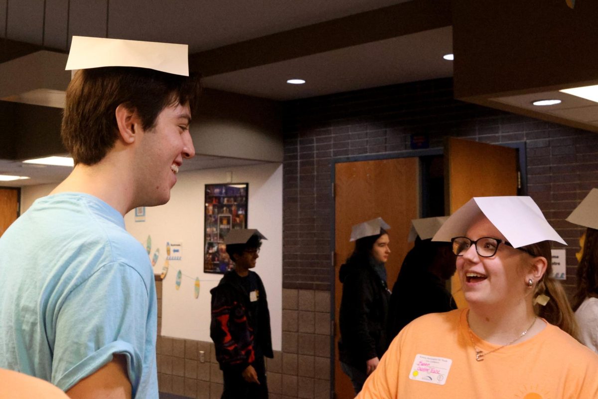 Junior Barron Fox shares a laugh with a K.A.Y. member from another school, while playing a game where they walk backwards with a piece of paper on their head Friday, Jan. 31