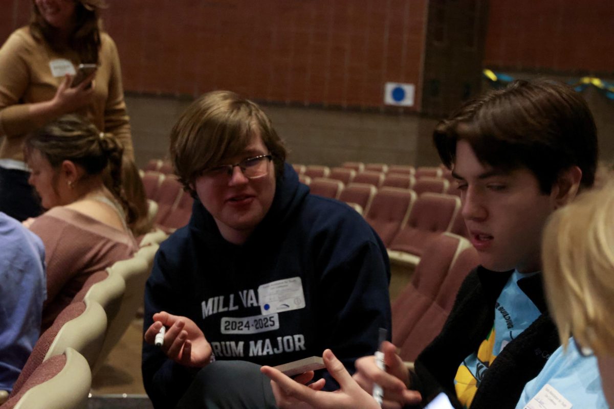 Junior Ian Weatherman discusses ideas for their service project, writing nice notes to put up around the school Friday, Jan. 31