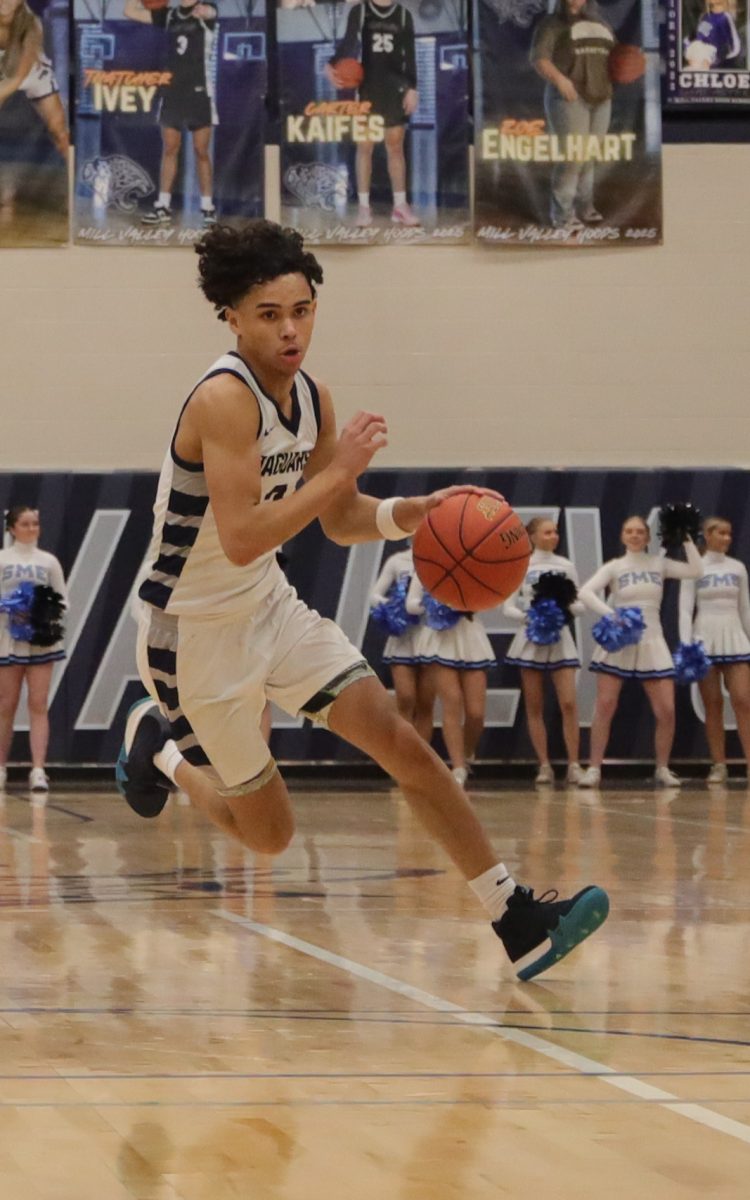 Dribbling, junior JaKhai Carter runs towards the hoop.
