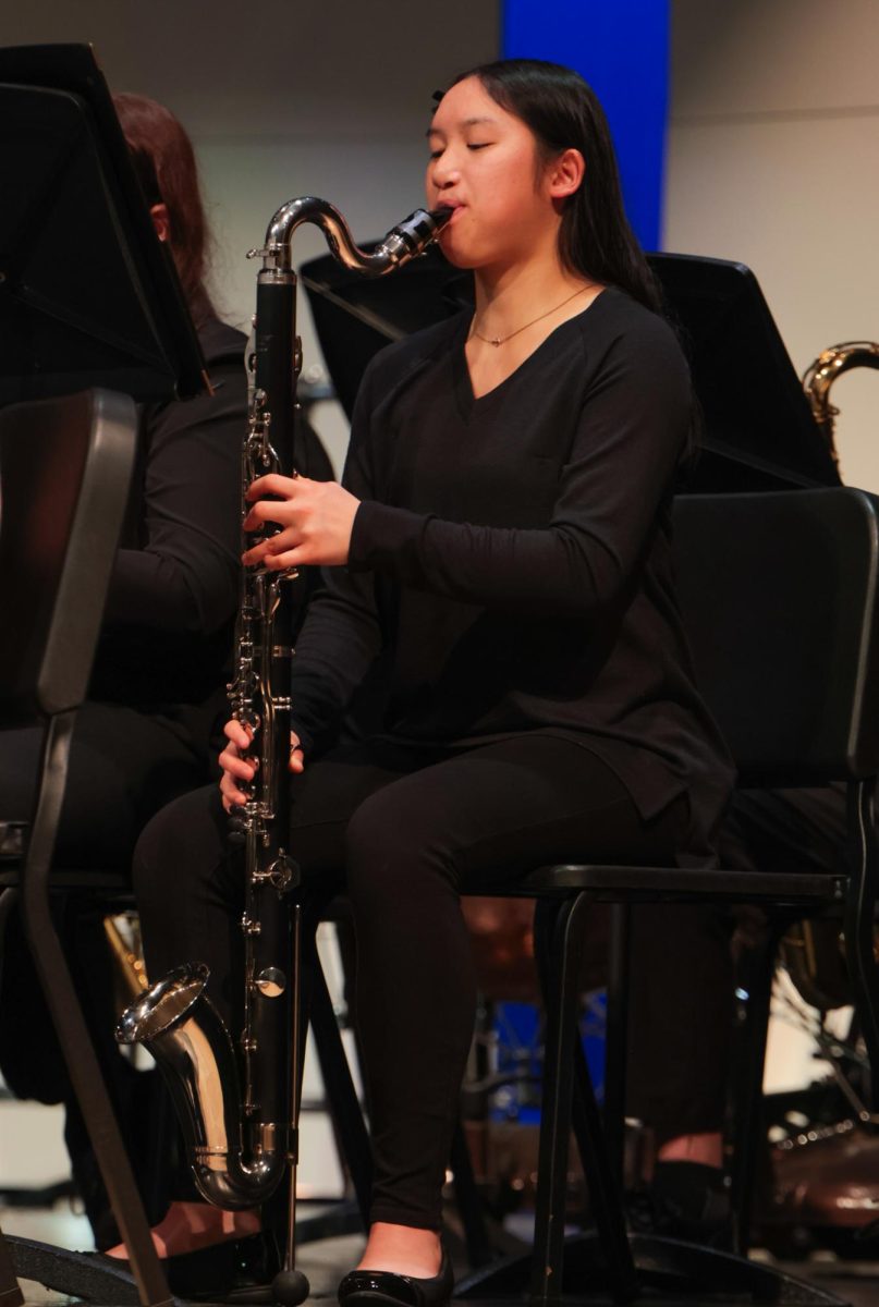 Playing her instrument, freshman Effie Niewohner follows along to the music.

