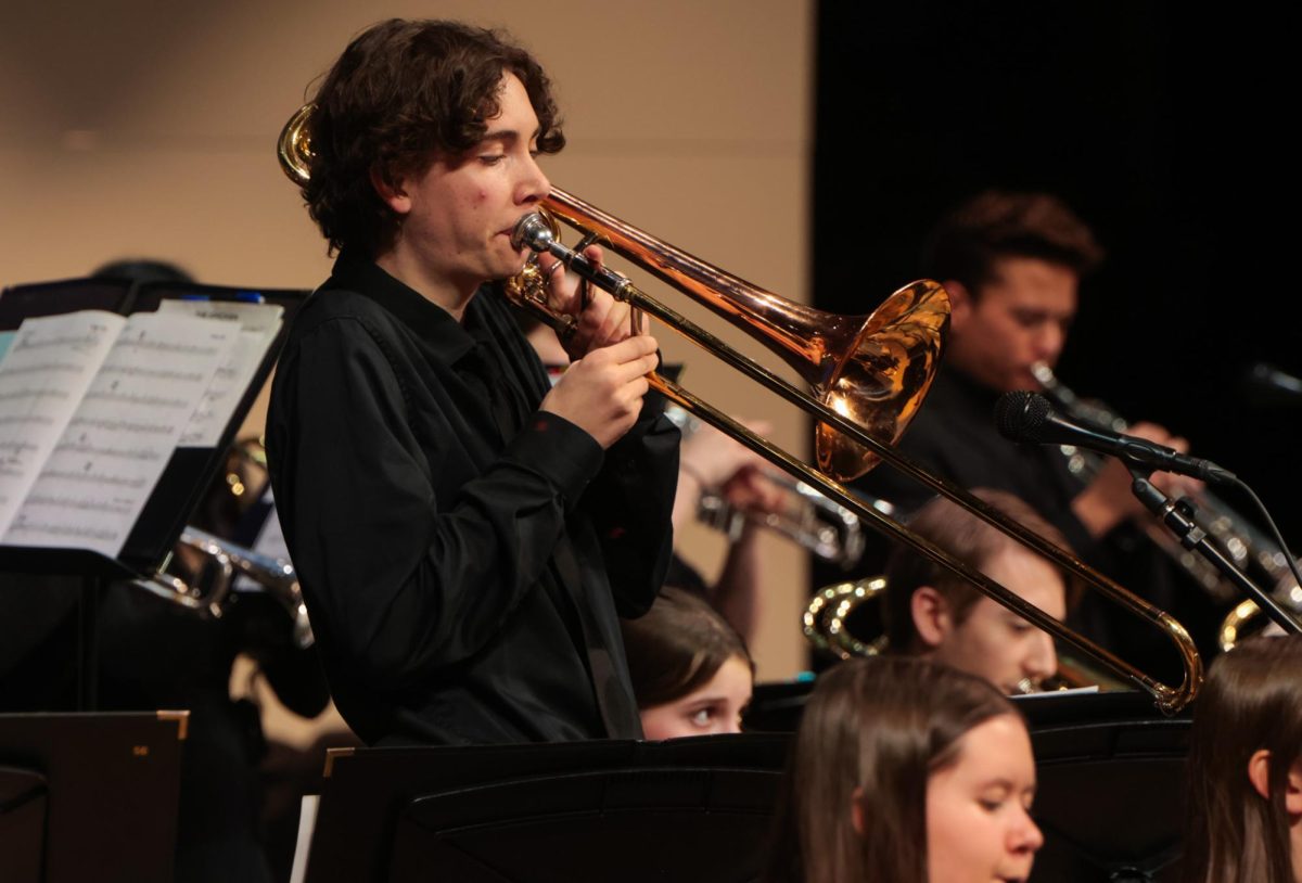 Standing up, junior Ethan Culver performs a solo in the middle of a piece. 
