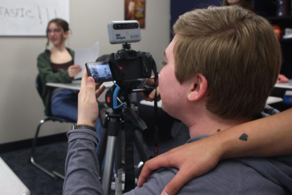 Junior Evan LeRoy adjusts the screen of his camera to get a better view of what he is filming, Thursday March, 14. 