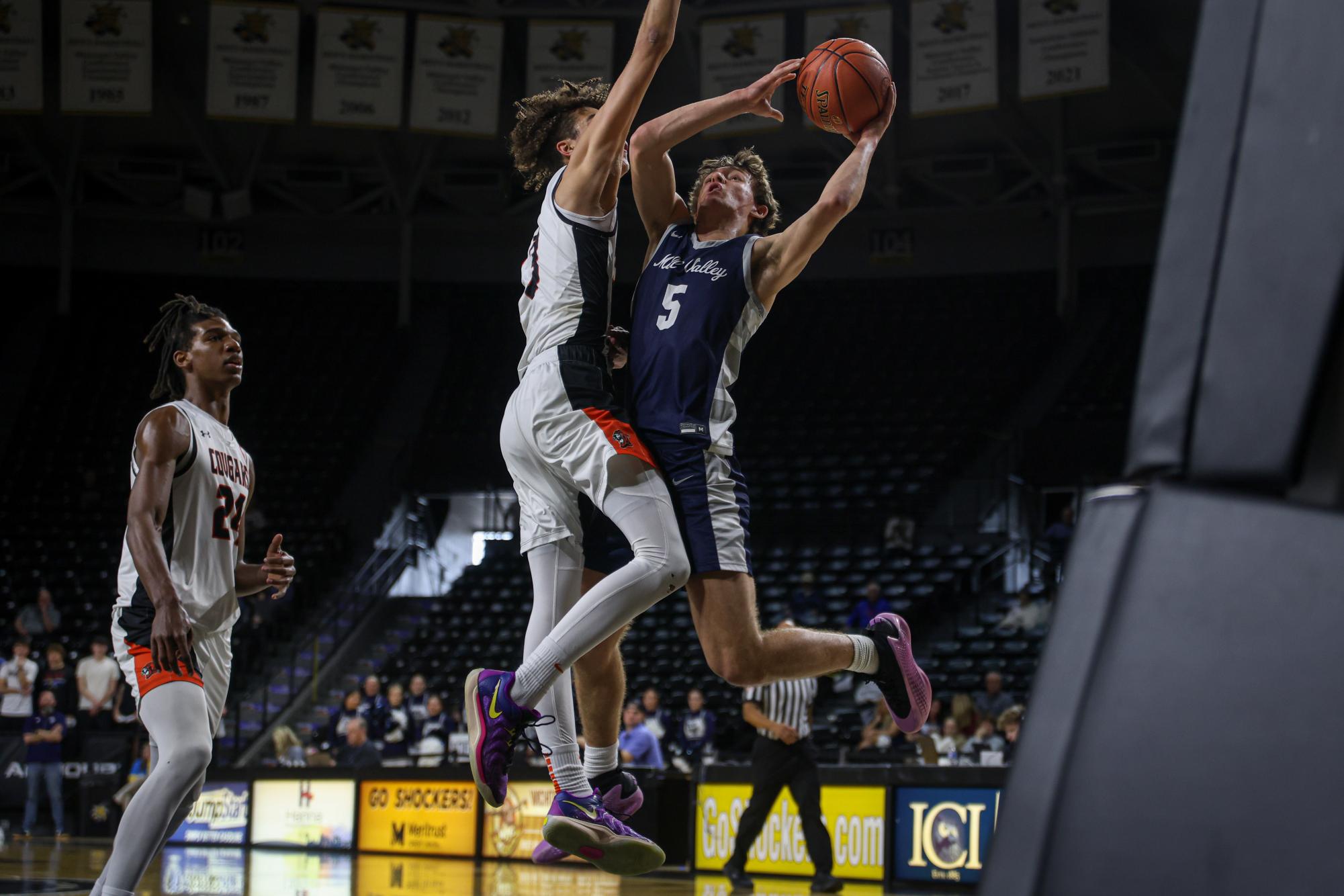 Twisting his upper body, junior Reese Riedel shoots a layup around the SMNW defender. 