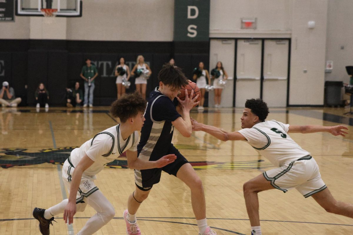 Junior Jack Carpenter drives through defenders to get to the basket