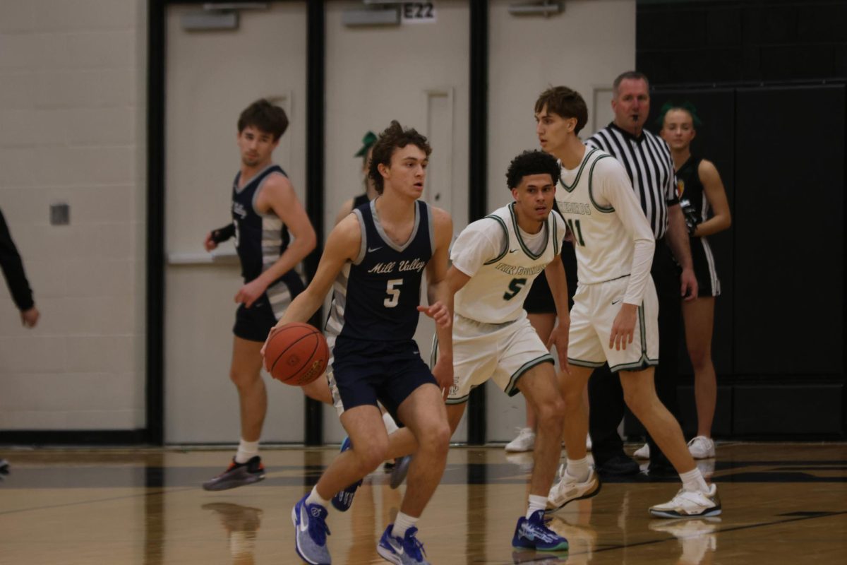 Junior Reece Riedel dribbles past a defender, looking for an open teammate