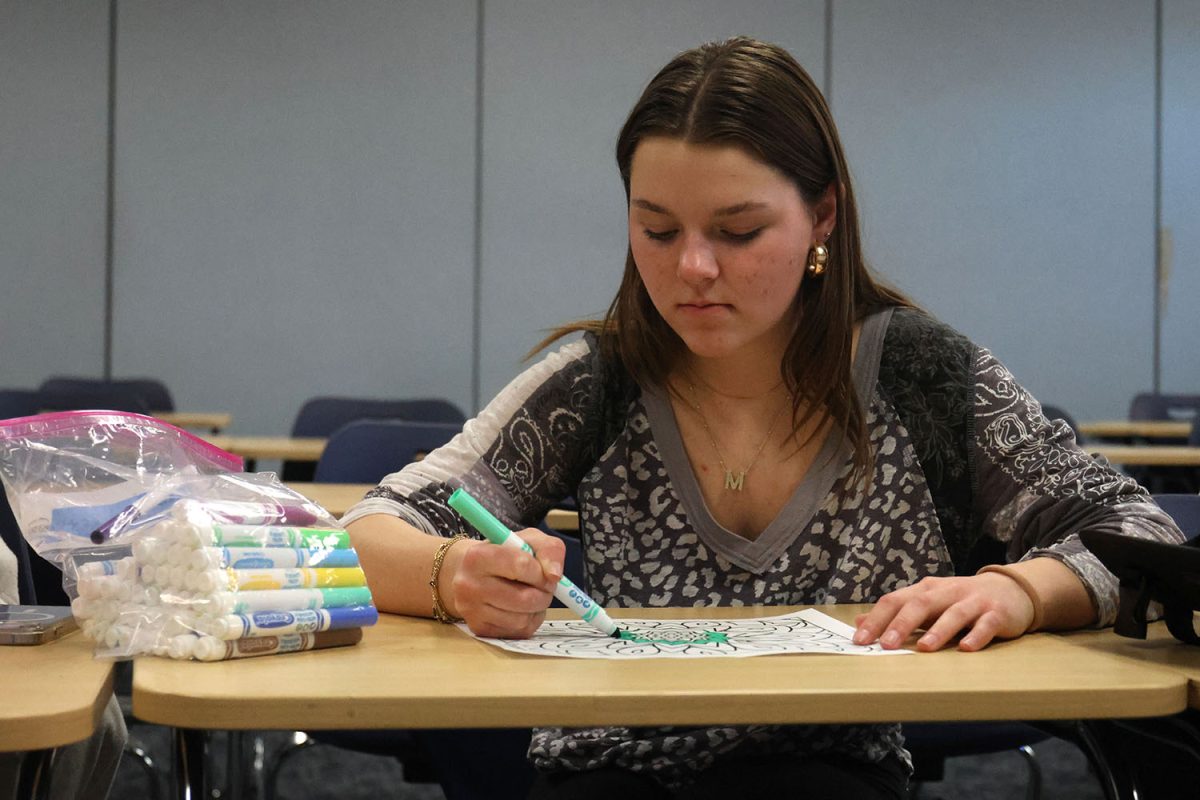 Coloring Club founder junior Maddie Martin focuses on her artwork.
