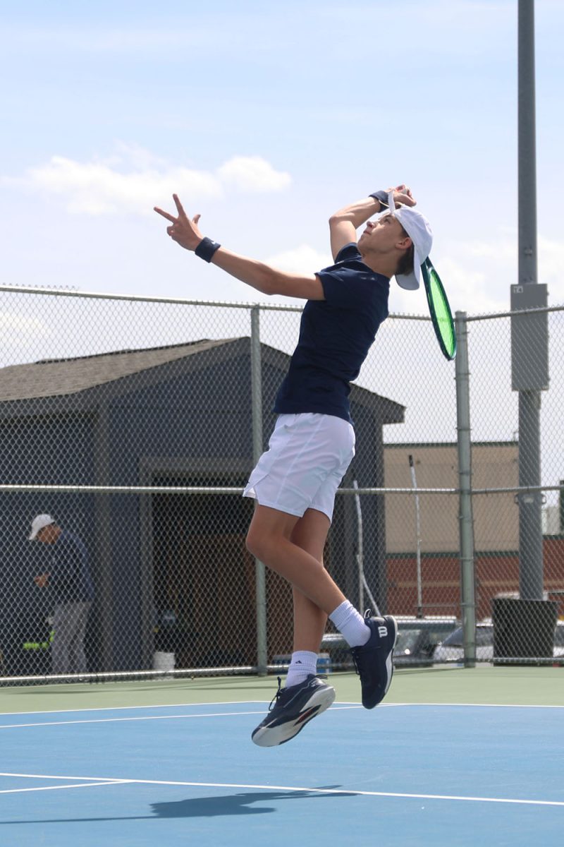 Jumping, freshman Dalton Parde returns the ball to his opponent.